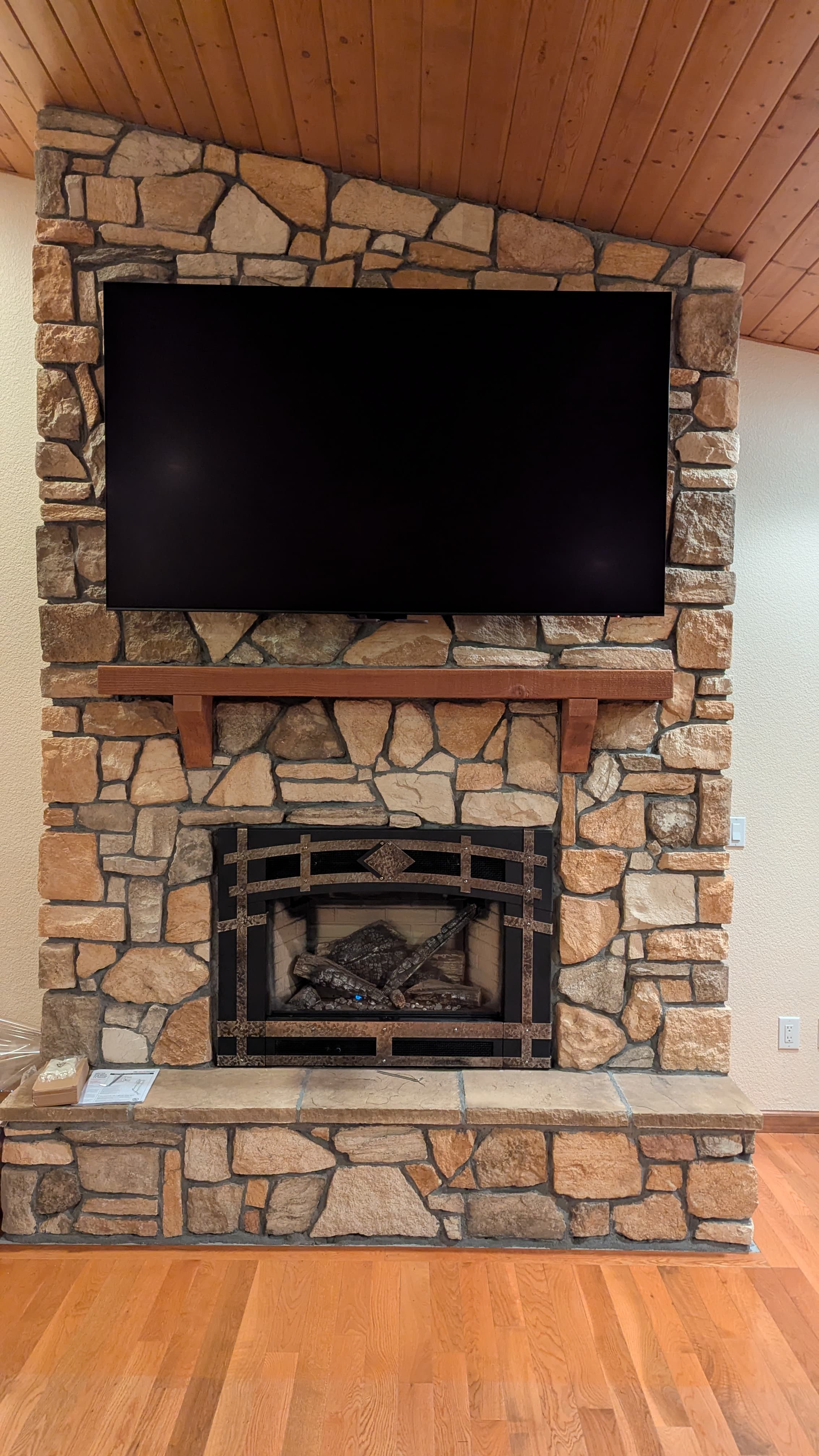 TV on rustic stone fireplace with wood ceiling in Colfax, CA