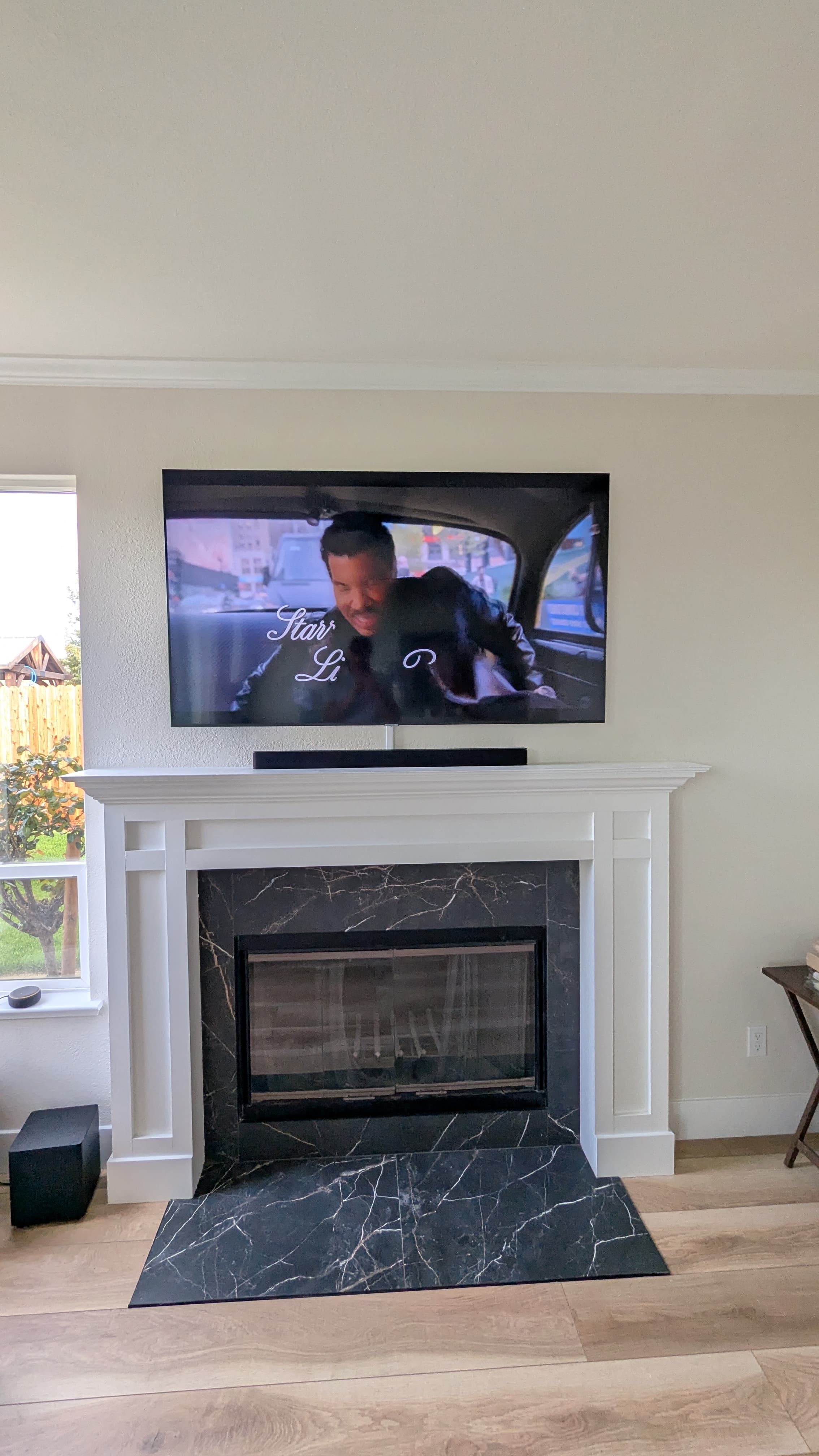 TV and soundbar above white mantel with black marble surround in Rocklin, CA