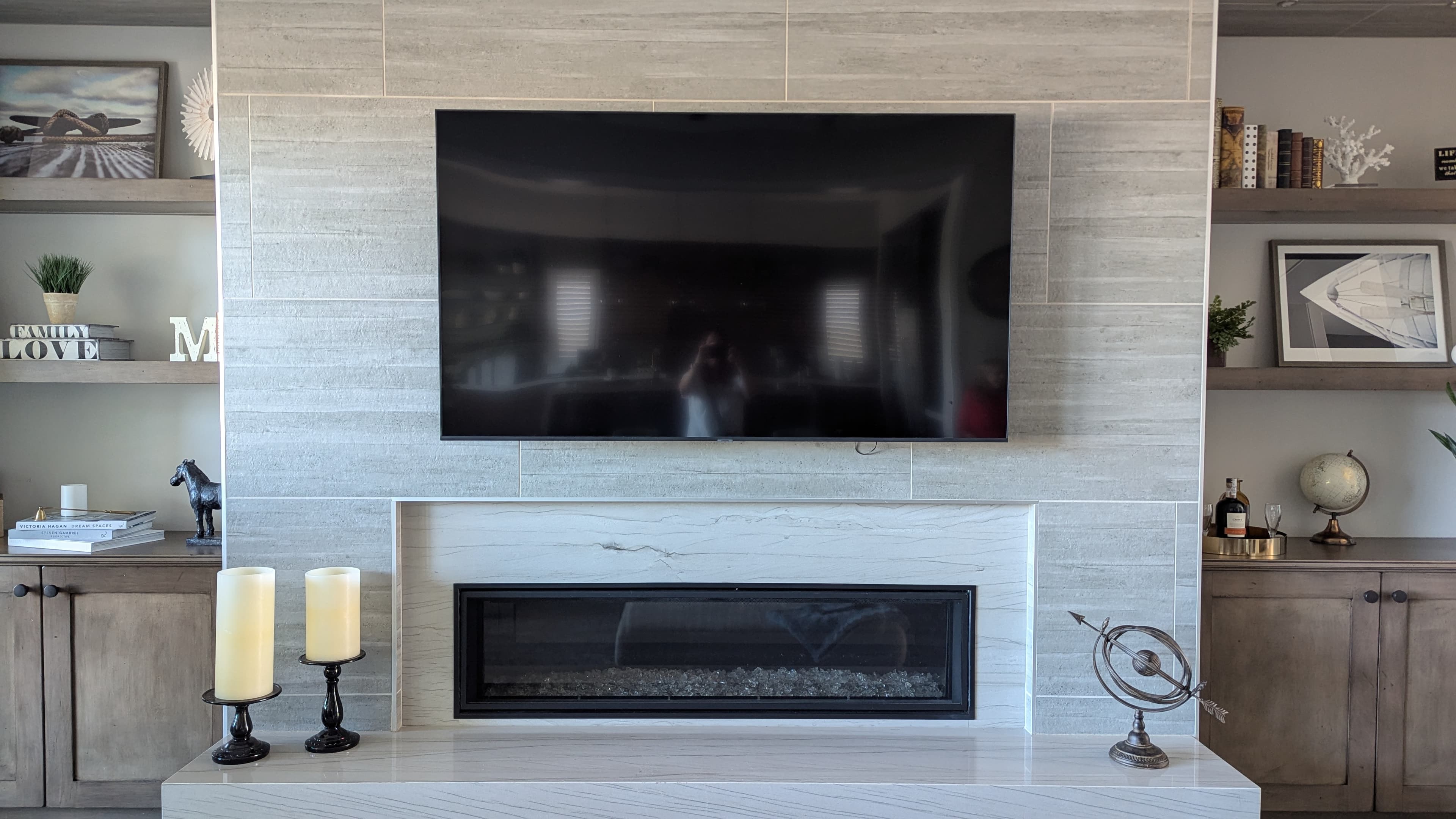 TV on tile surround above linear fireplace with built-in shelves in Rocklin, CA