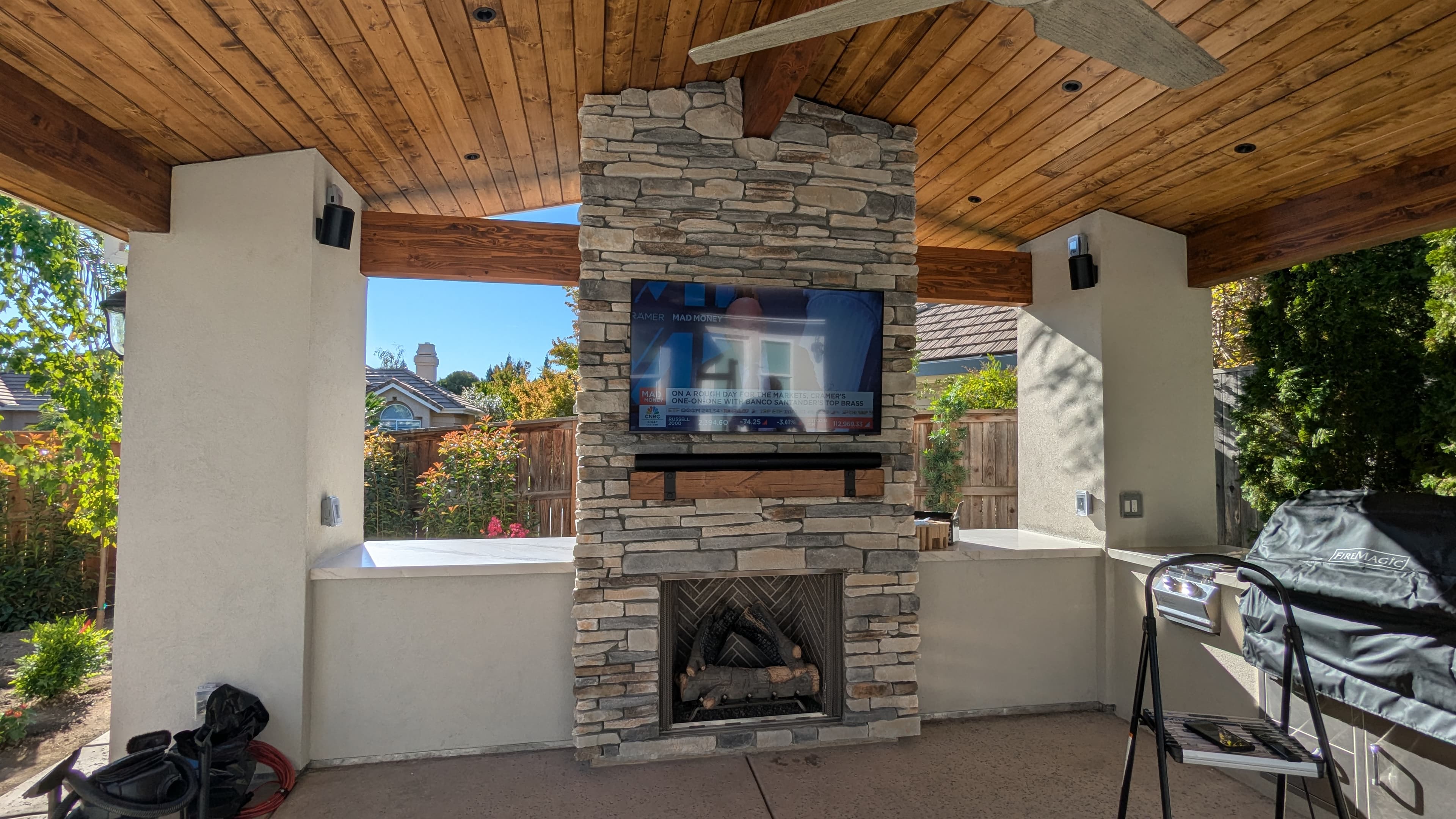 Outdoor TV on stone fireplace under pavilion with speakers in Granite Bay, CA