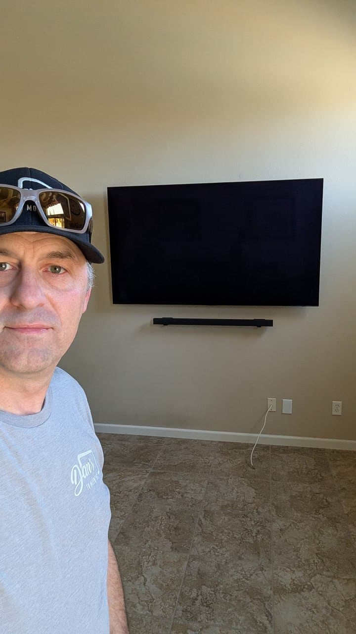 Dan with large TV and wall-mounted soundbar with wires hidden in wall in Roseville, CA