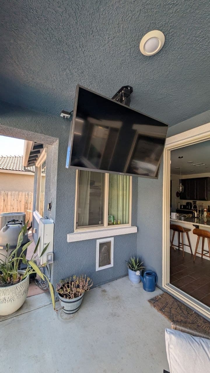 Fold-down outdoor TV mount on covered stucco patio in Rancho Cordova, CA