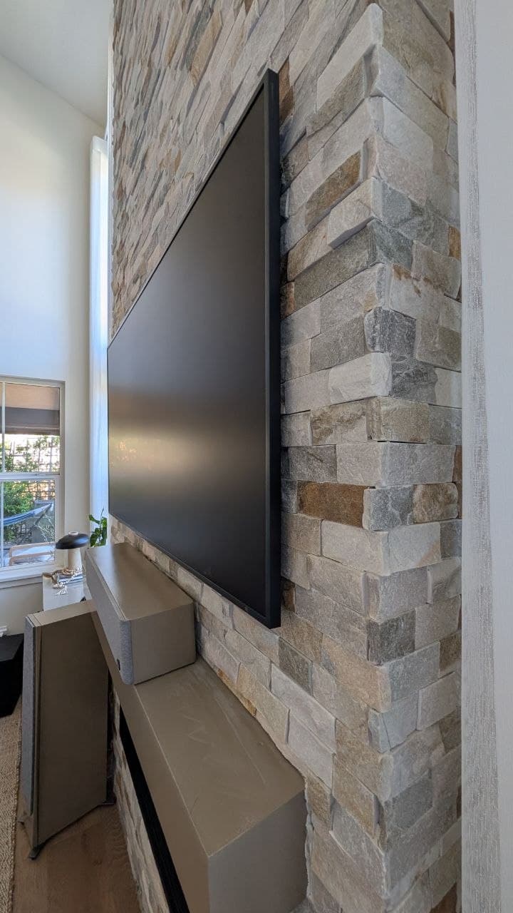 Close-up of Samsung Frame TV sitting flush against stacked stone fireplace in Granite Bay, CA