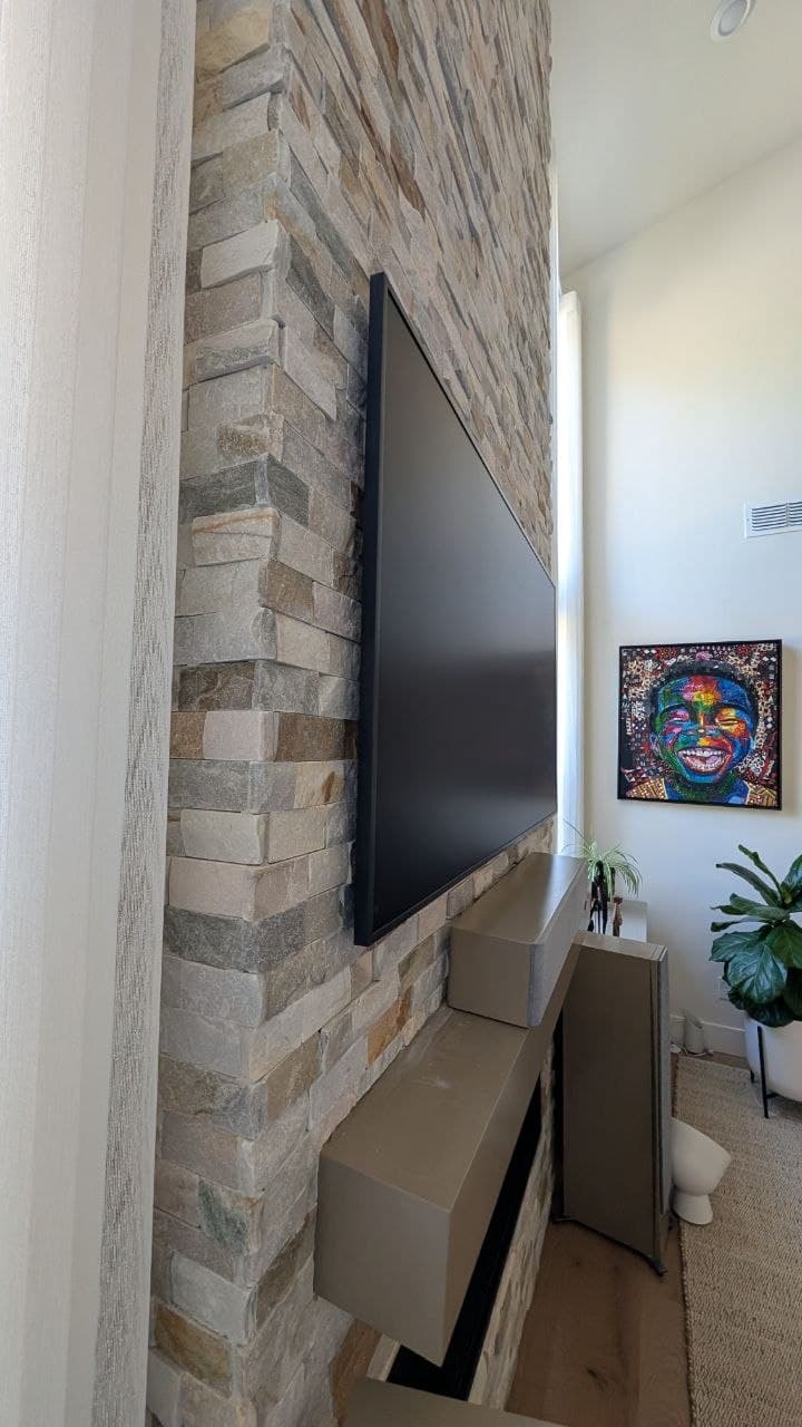 Side angle showing Samsung Frame TV flush against stacked stone wall in Granite Bay, CA
