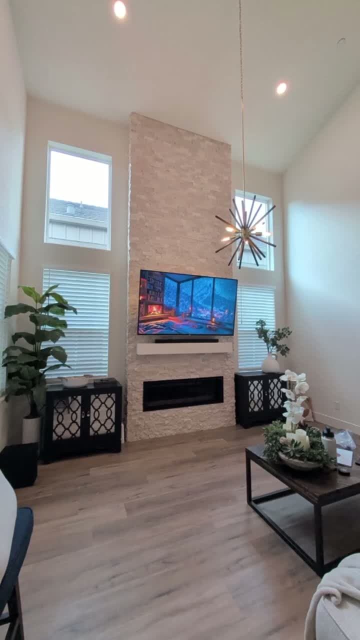Full room view of 80-inch TV on stone fireplace with vaulted ceilings and modern living room in Granite Bay, CA