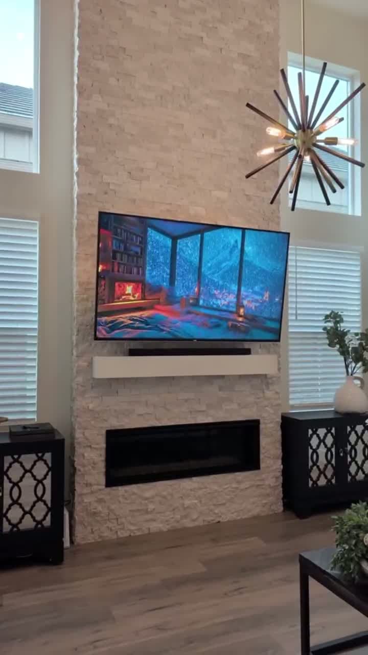 80-inch TV mounted on floor-to-ceiling ledger stone fireplace with soundbar on floating shelf in Granite Bay, CA