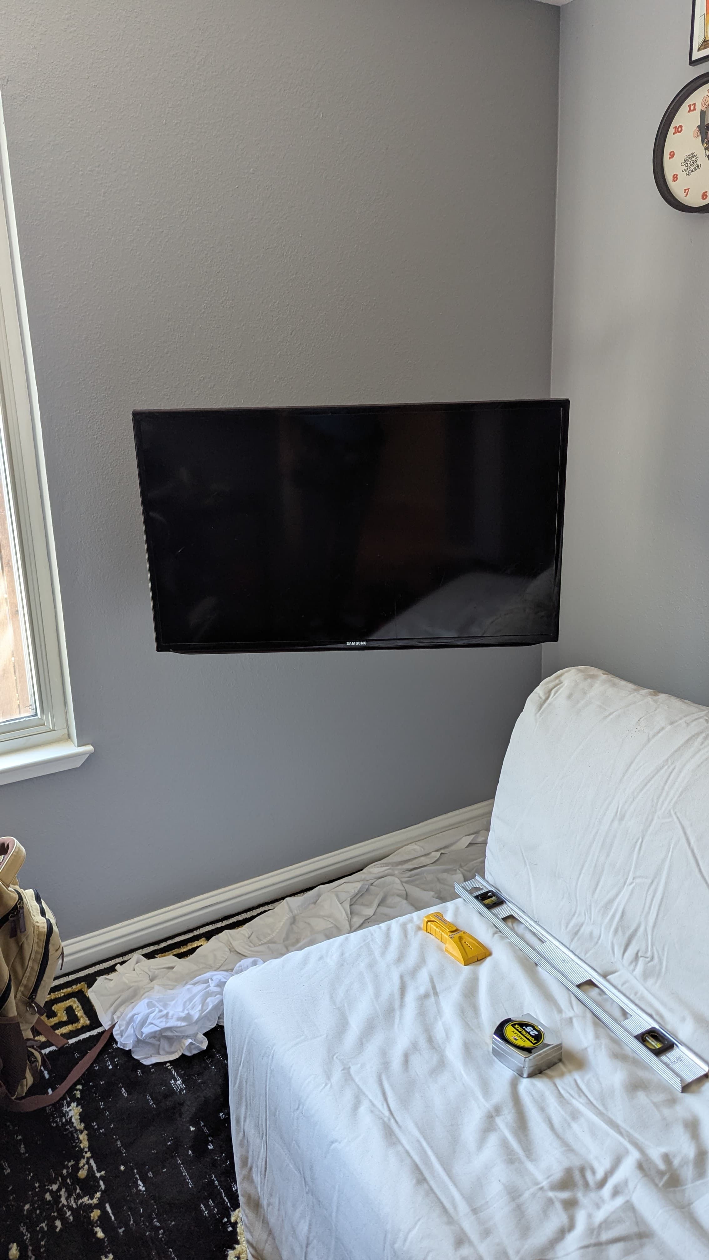 TV mounted flush in corner during installation with level and tools in Sacramento, CA