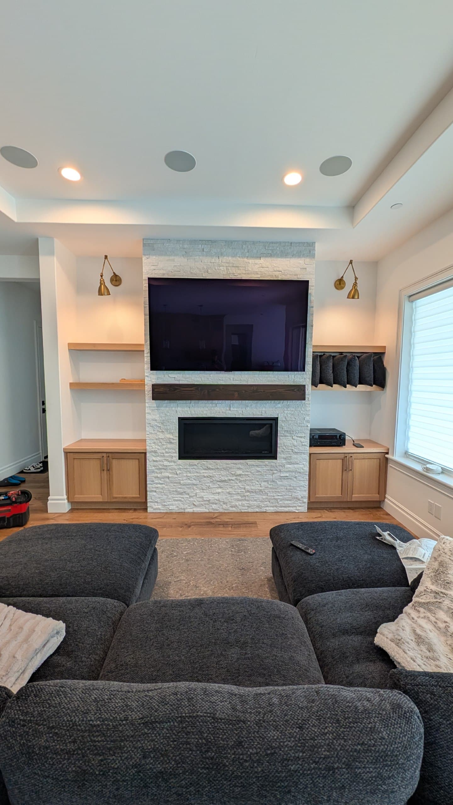 TV mounted above stone fireplace with built-in cabinetry and floating shelves in El Dorado Hills, CA