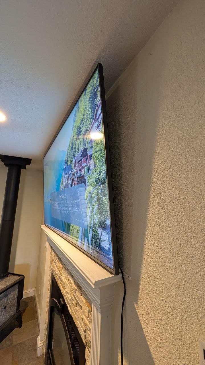 Side angle showing tight clearance between 75-inch LG TV and ceiling above fireplace in Placerville, CA