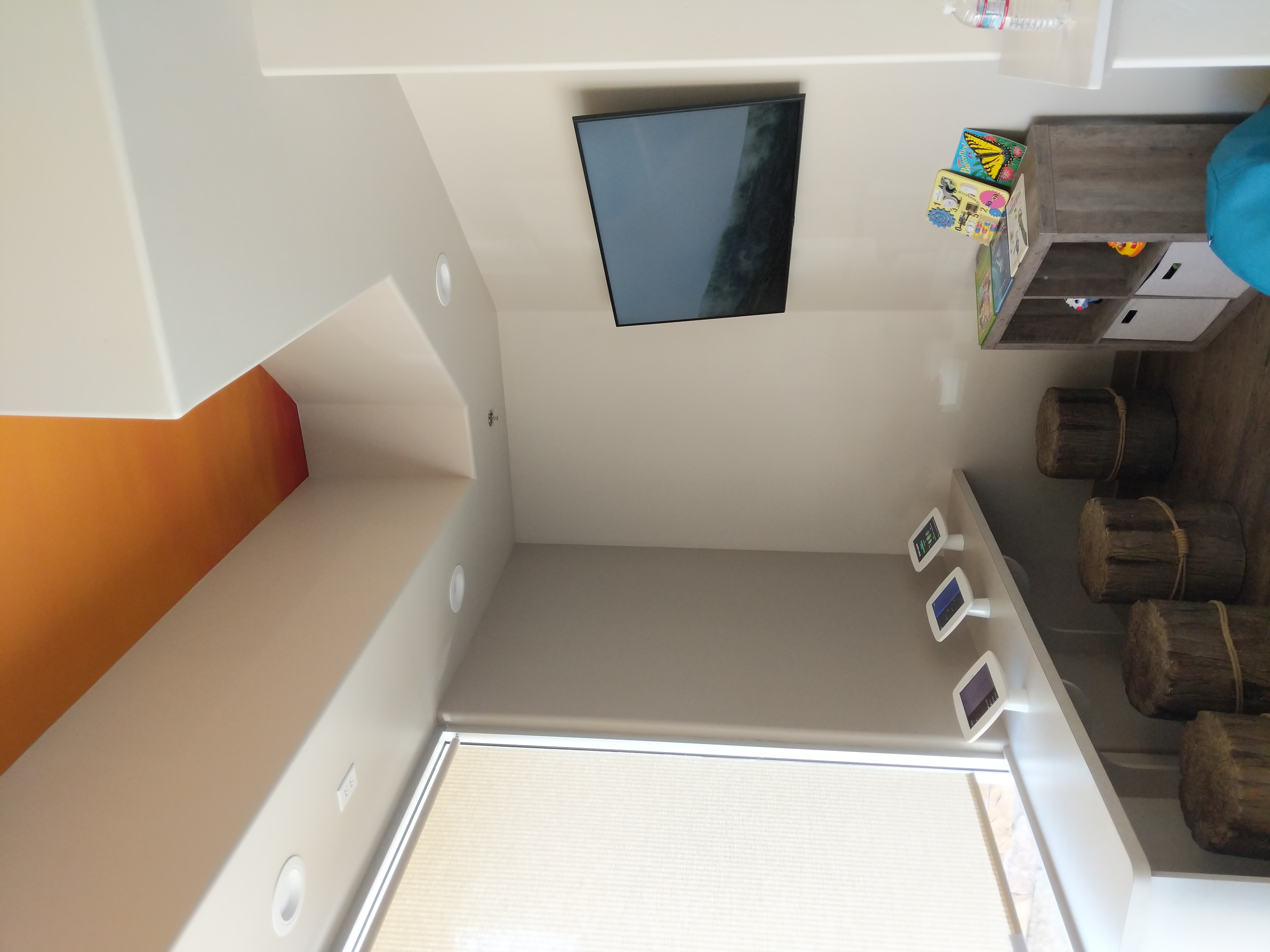 TV mounted in kids room with orange accent wall in Roseville, CA