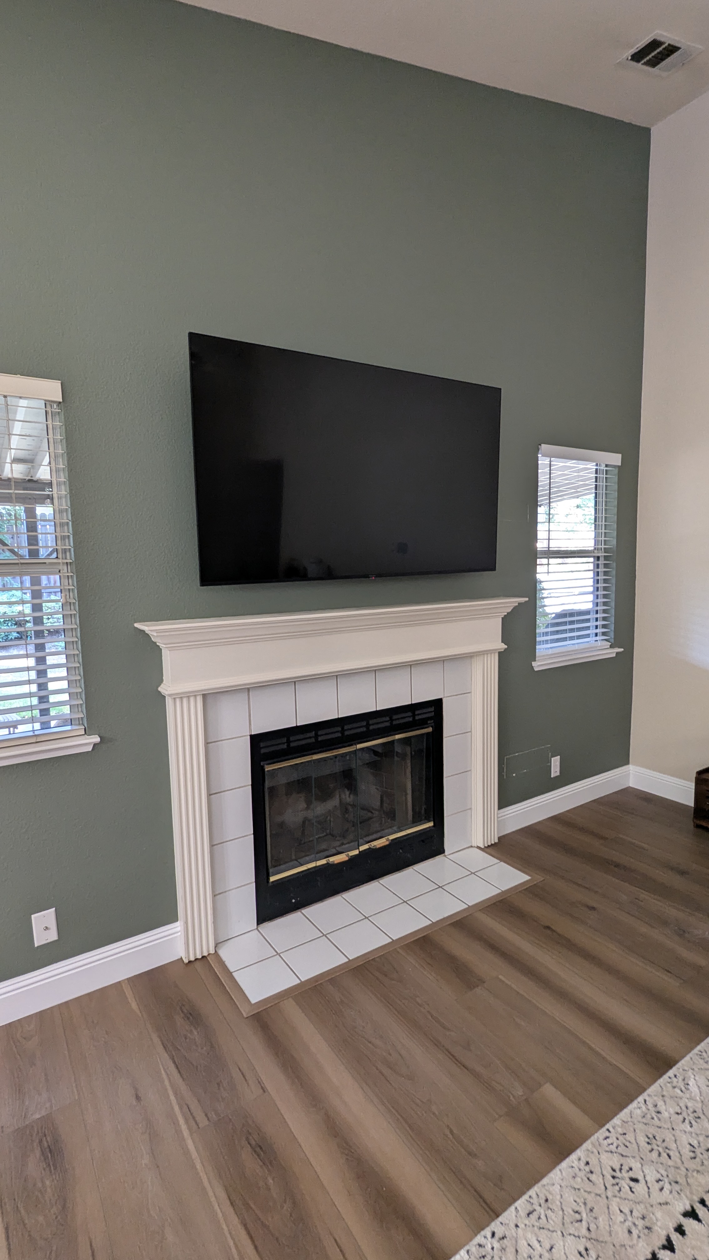 TV above fireplace on sage green accent wall in Roseville, CA