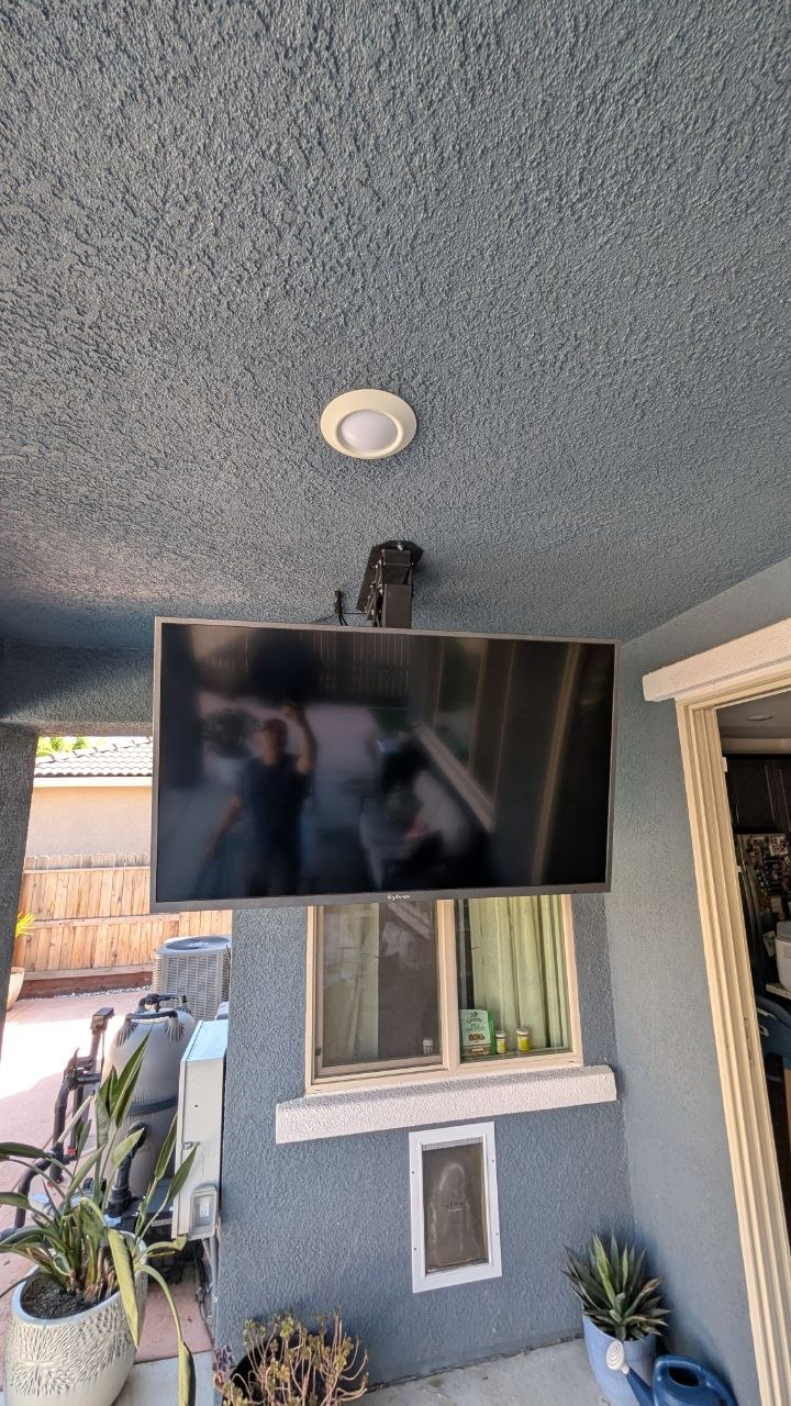 Outdoor TV in fold-down viewing position on stucco patio wall in Rancho Cordova, CA