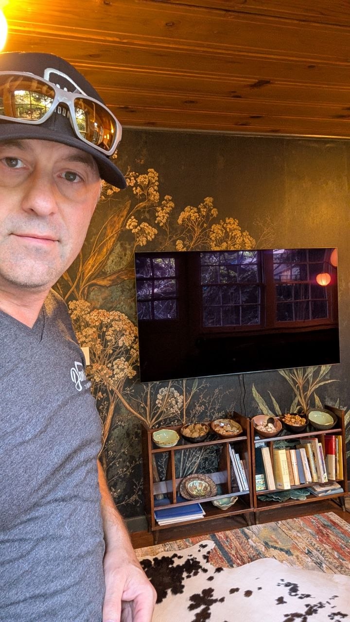 Dan with 65-inch LG C5 on Sanus full motion mount against botanical wallpaper mural in Sacramento, CA
